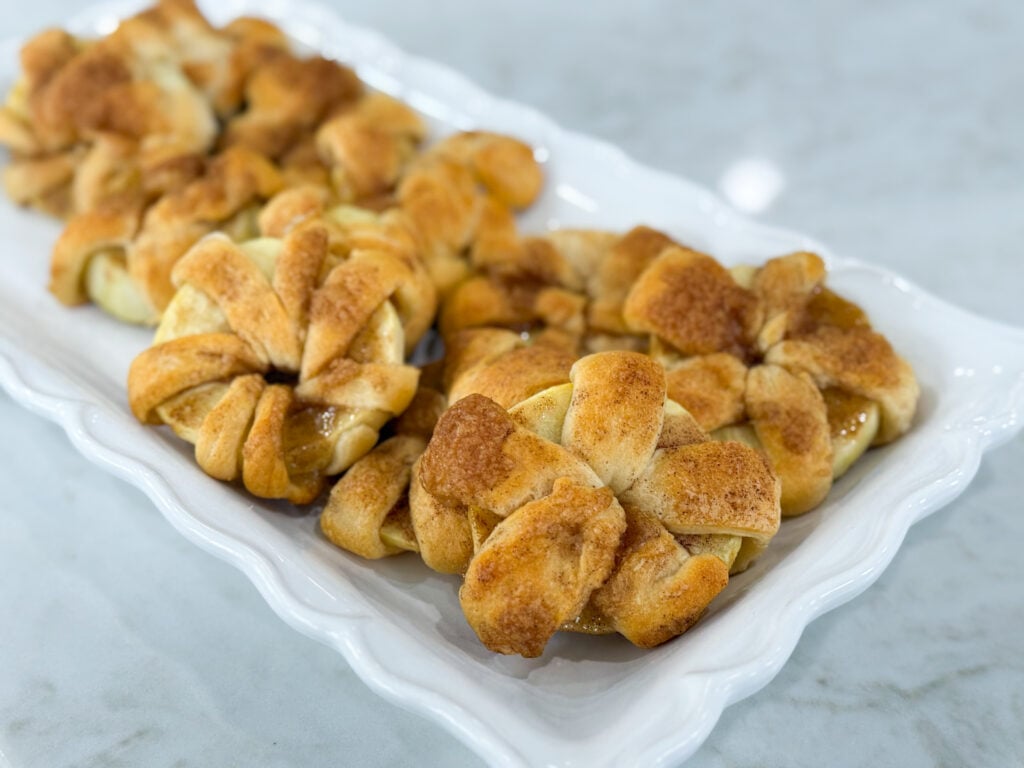 Golden baked apple crescent donuts dusted with powdered sugar