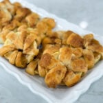 Golden baked apple crescent donuts dusted with powdered sugar