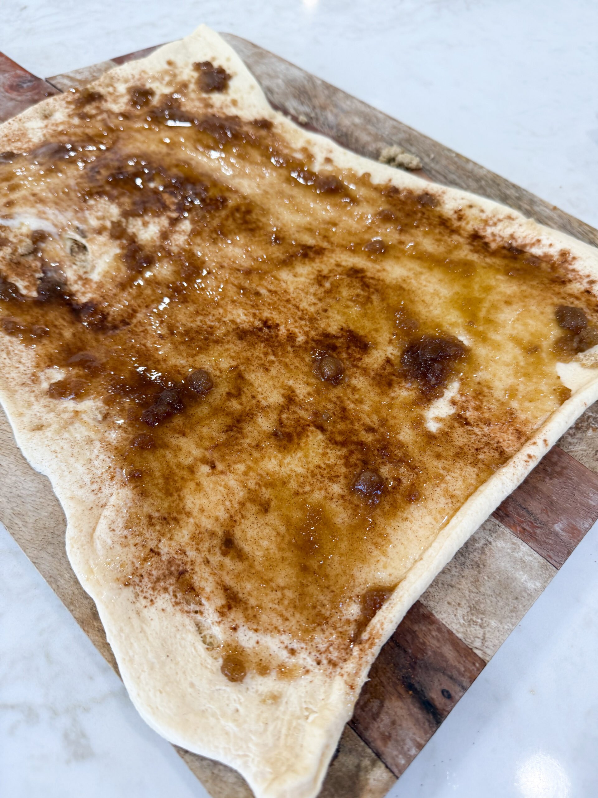 Sprinkling cinnamon sugar over dough