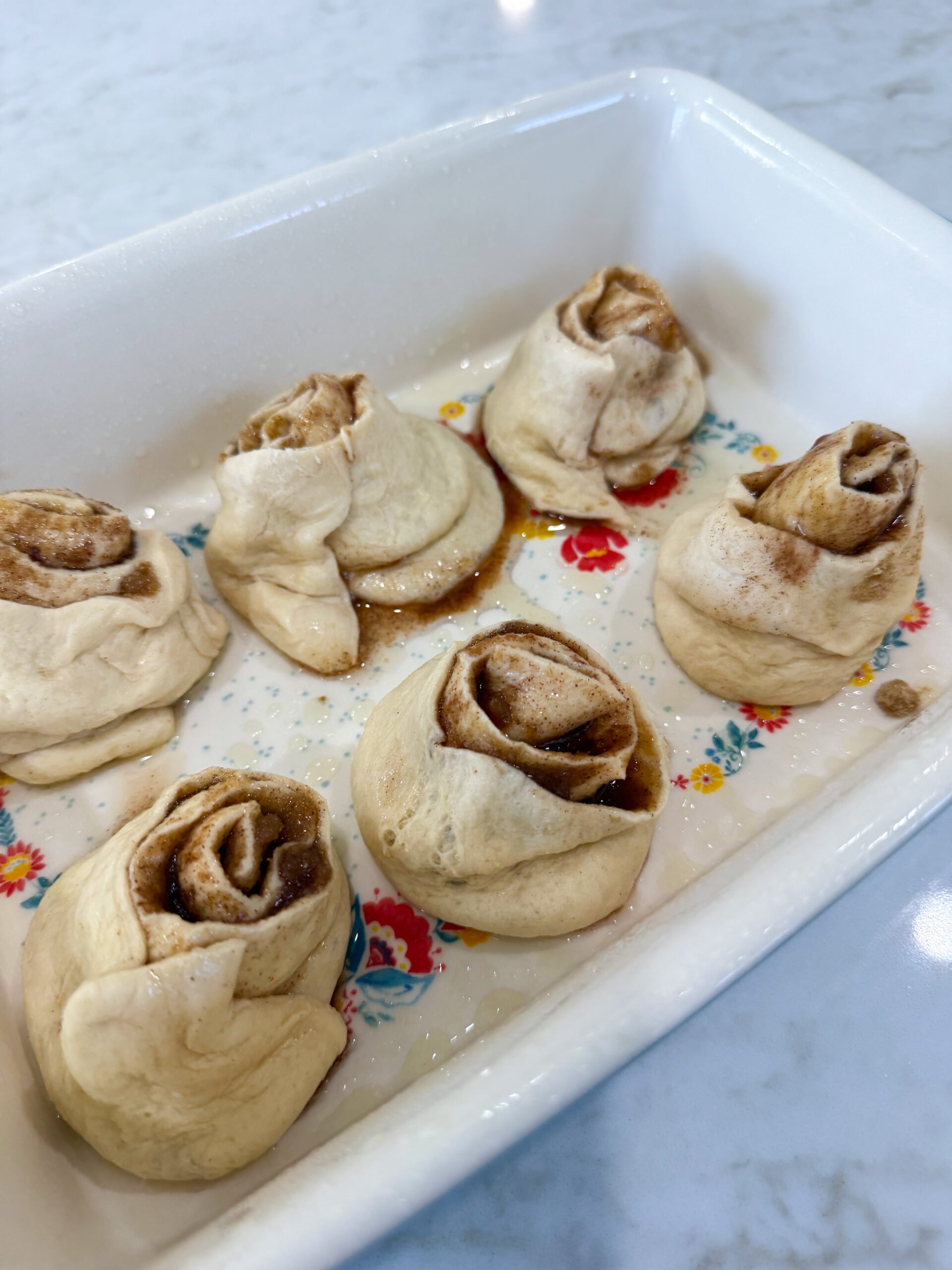 Sliced cinnamon rolls in baking dish ready for oven
