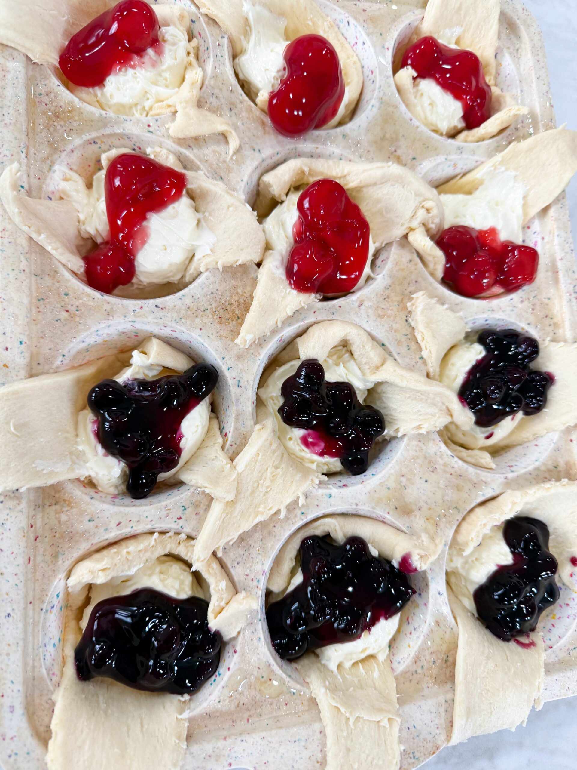 Golden mini cheesecake pies topped with blueberry and raspberry filling