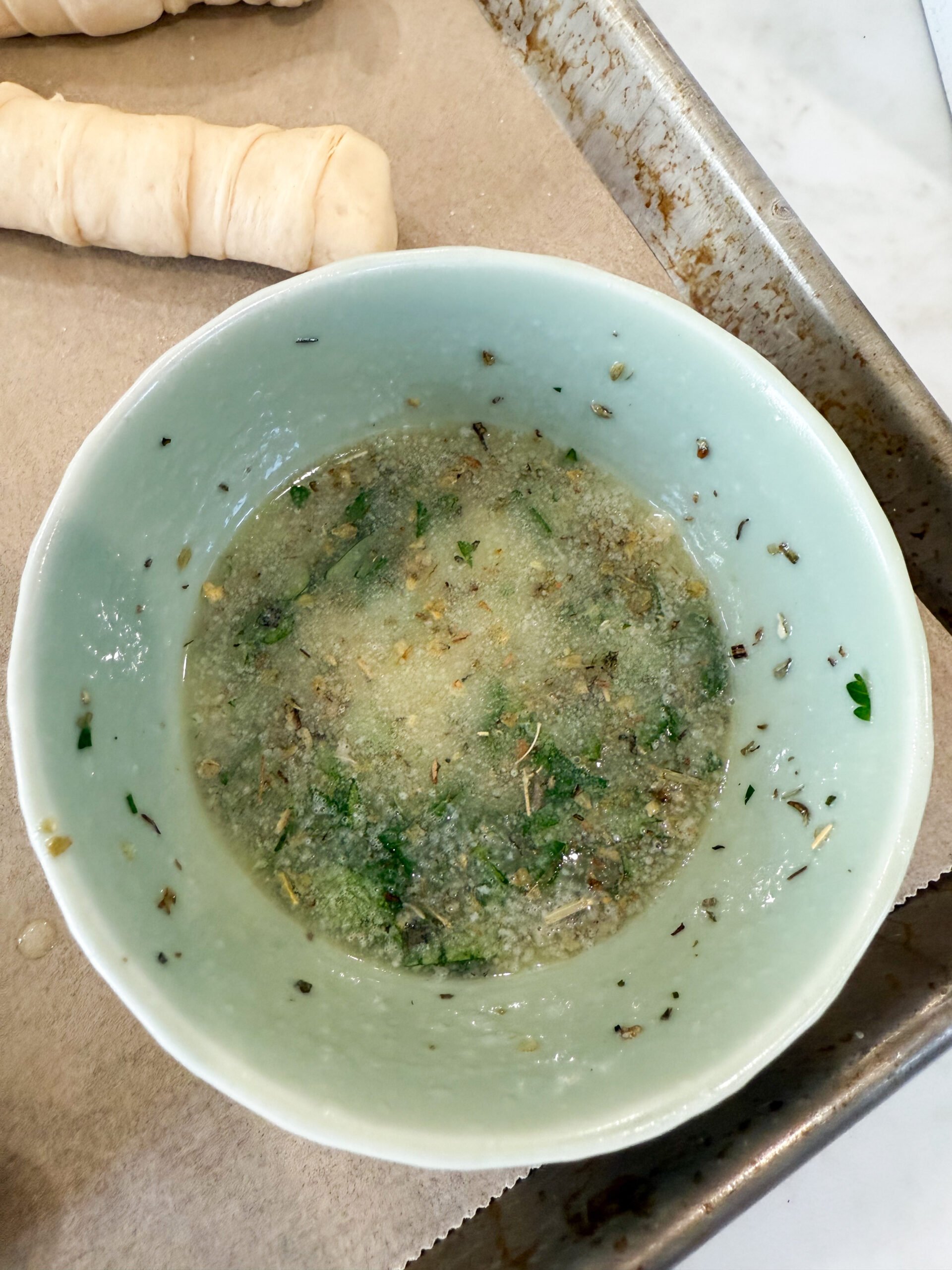 Melted butter, parsley, garlic, and Italian seasoning combined in a bowl