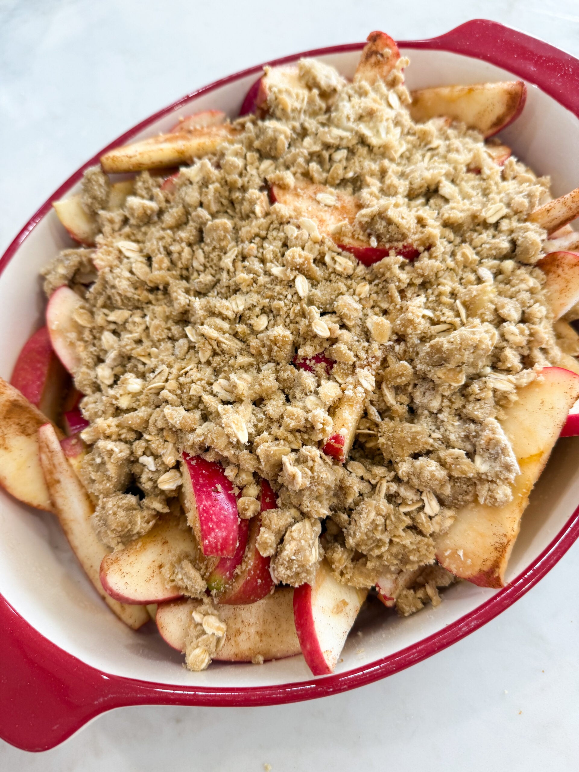 Crisp topping sprinkled over apples in baking dish