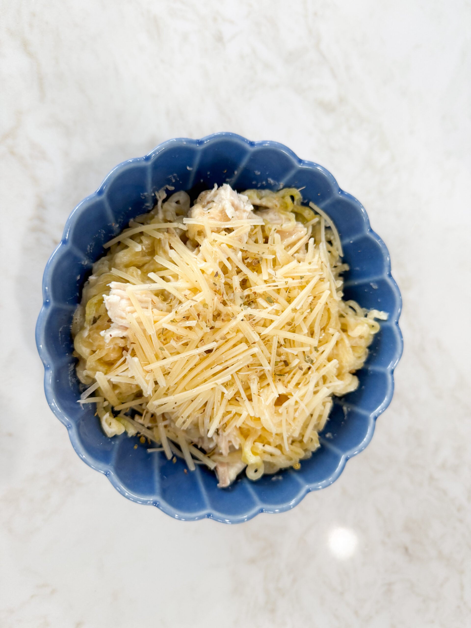 Chicken Alfredo Ramen Bake portioned into a bowl and topped with parmesan cheese