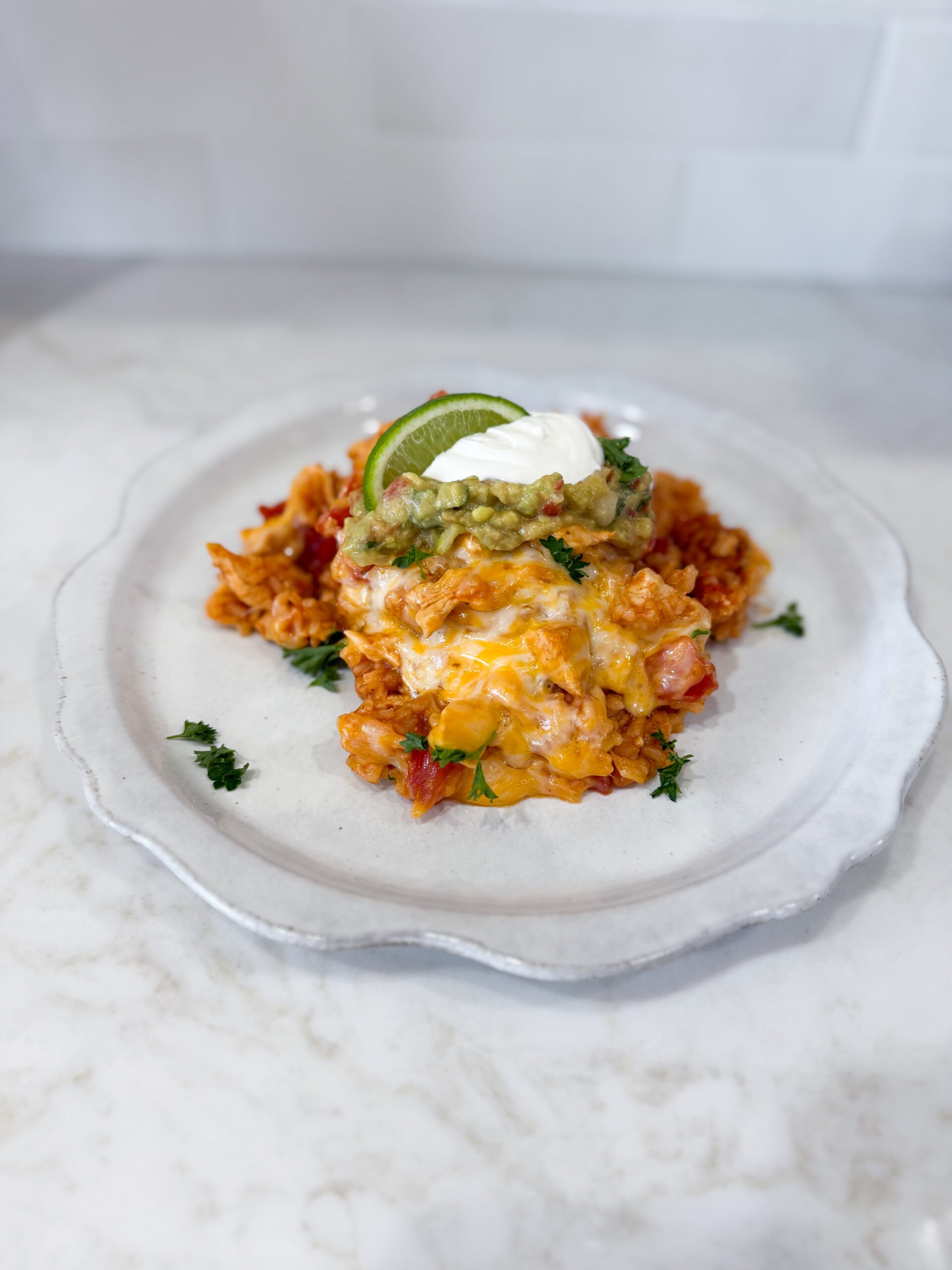 chicken taco rice plated and topped with lime and sour cream