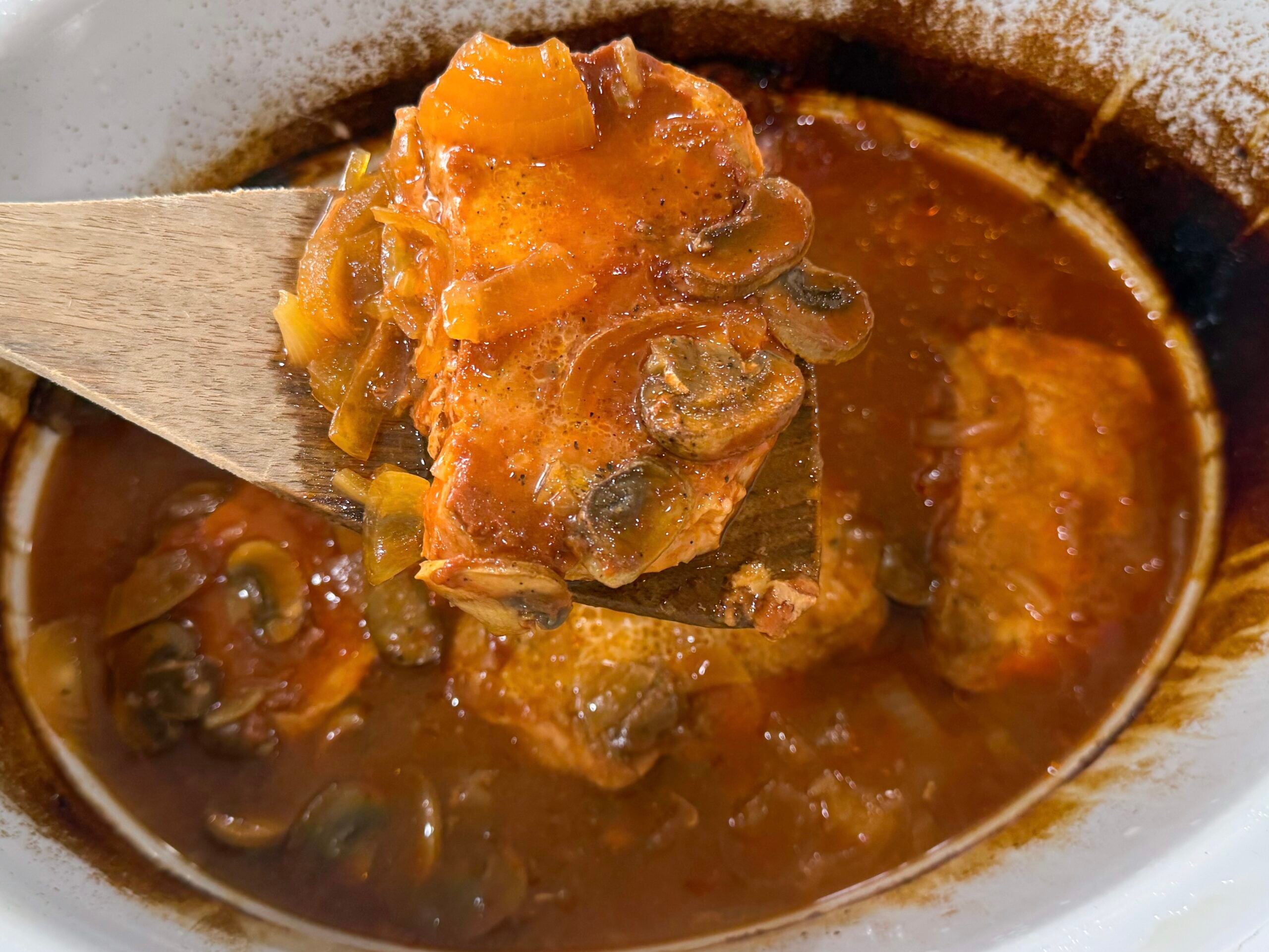 cooked pork chops covered with onion mushroom gravy in a slow cooker