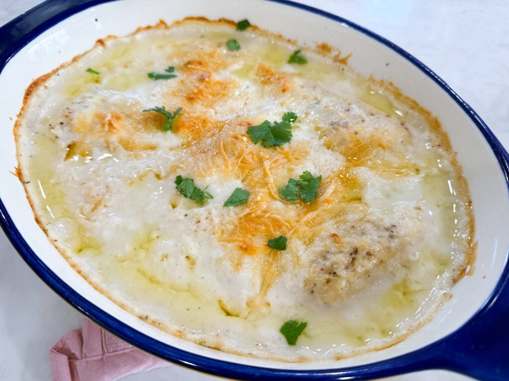 Chicken Alfredo bake topped with creamy Alfredo sauce and Parmesan cheese